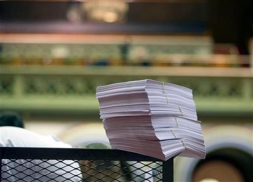Budget bills are stacked on a cart before being distributed in the Assembly Chamber at the Capitol on Tuesday, March 31, 2015, in Albany, N.Y. Lawmakers plan to vote Tuesday on the final provisions of the state budget, including changes to teacher evaluations and an ethics proposal intended to clean up Albany's pernicious corruption problem.