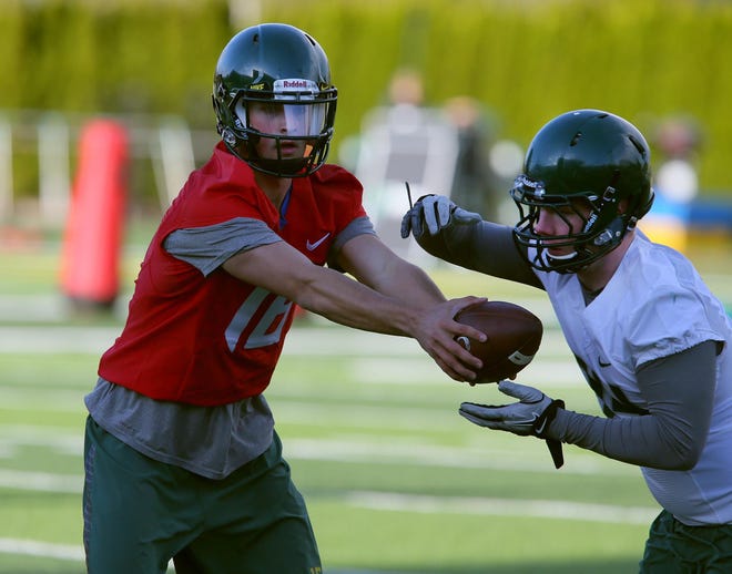 Quarterback Morgan Mahalak hands off to running back Lane Roseberry during Oregon's opening day of spring practice at the Hatfield-Dowlin complex. (Brian Davies/The Register-Guard)
