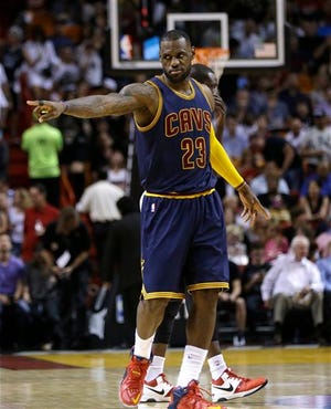 The Cavaliers' LeBron James (23) points before the March 16 game against the Heat in Miami.