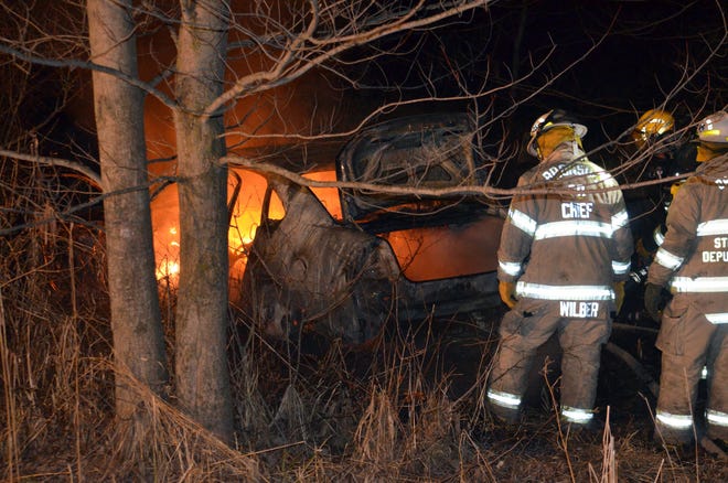Bronson firefighters douse a car on fire Tuesday night in Noble Township off Orland Road. Don Reid photo