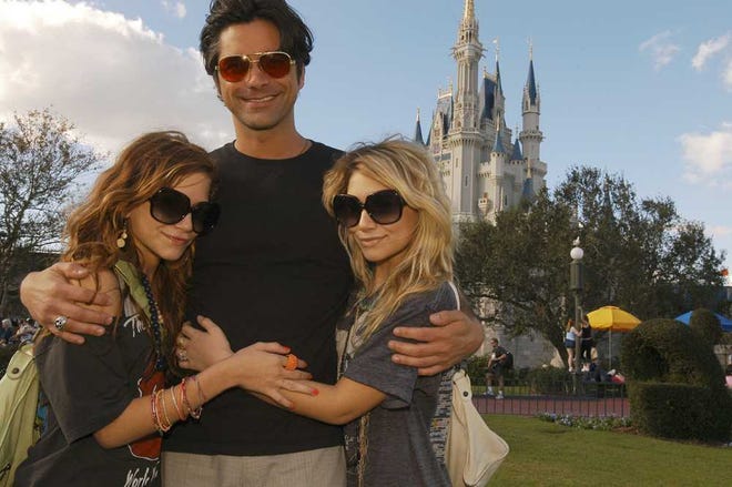 In a photo released by Walt Disney World, Mary-Kate, left, and Ashley Olsen are seen with actor John Stamos, Sunday, Jan. 2, 2005, at Walt Disney World Resort in Lake Buena Vista, Fla. The three co-stars of the popular 1980s and 1990s sitcom "Full House" are on vacation at Disney World. (AP Photo/Walt Disney World, Mark Ashman)