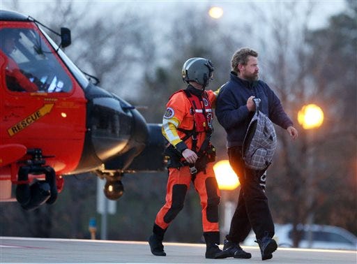 Louis Jordan, right, walks from the Coast Guard helicopter to the Sentara Norfolk General Hospital in Norfolk, Va., after being found off the North Carolina coast, Thursday, April 2, 2015. His family says he sailed out of a marina in Conway, S.C., on Jan. 23, and hadn't been heard from since. (AP Photo/The Virginian-Pilot, Steve Earley)