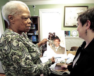 arbara Adams Pierce (left) shows Sherie Brown, director of the Massillon Public Library, a photograph of her daughter, Ida “Mikey” Pierce Bolls, taken while Bolls served in the U.S. Army. In the upper right background is an original 1894 Stark County map displayed in Bolls' honor at the library.