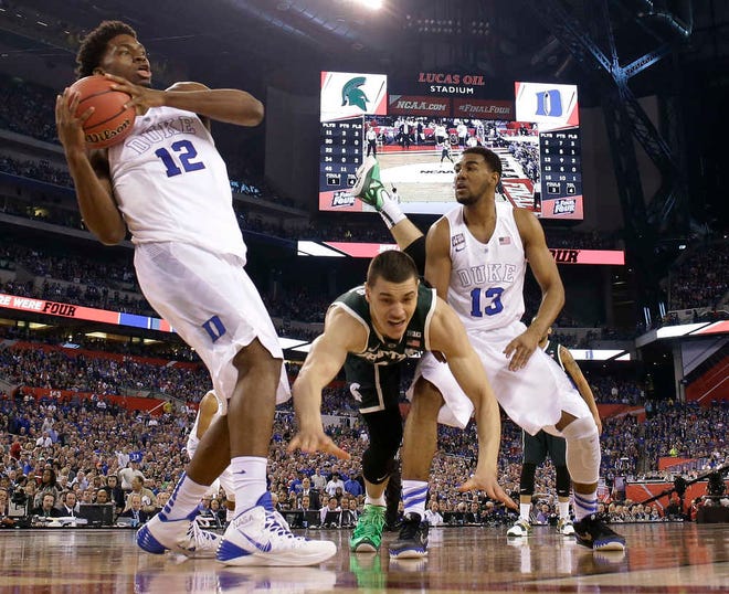 Michigan State's Gavin Schilling, center, loses the ball between Duke defenders Justise Winslow, left, and Matt Jones, right, during the second half of the NCAA Final Four tournament college basketball semifinal game Saturday, April 4, 2015, in Indianapolis. (AP Photo/Michael Conroy)