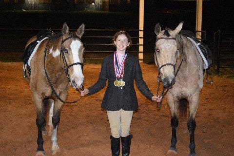 Mattie Mills stands with horses Dun Bar Blazin Wind and Too Nifty For Sox as she shows off awards she won in competition.