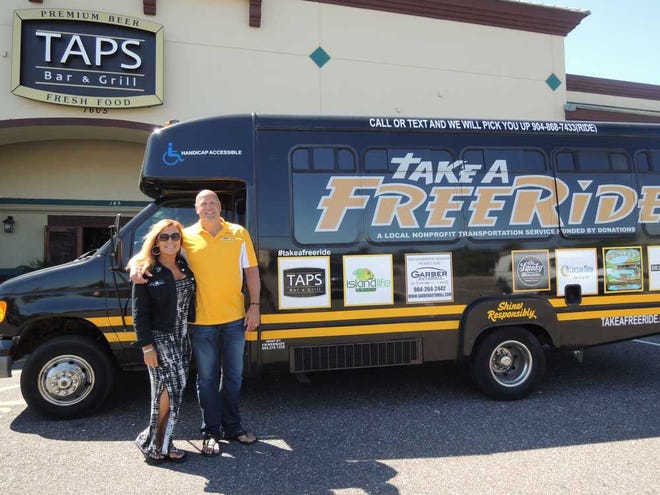 Tiffanie.Reynolds@jacksonville.com Jules and Todd Carlson display their "Take a Free Ride" bus at Taps Bar and Grill in Fleming Island.