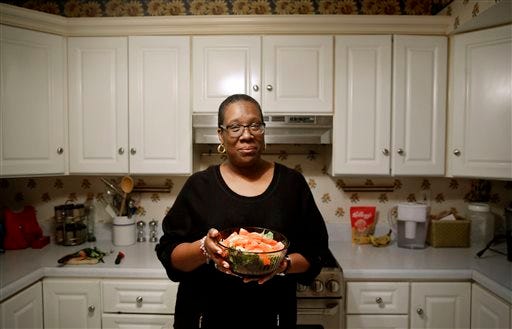 In this April 3, 2015 photo, Michele Rouse holds a salad that she made in her kitchen in Edgewood, Md. Rouse says she has lost 7 pounds since she started on Weight Watchers a month ago and has already seen a drop in her elevated blood pressure. Weight Watchers and Jenny Craig scored the best marks for effectiveness in a review of research on commercial diet programs, but many other plans just haven't been studied enough to evaluate long-term results.