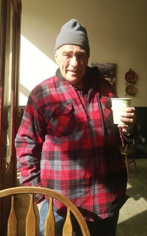 Alvin Mosch, a resident of Idaho Springs, Colorado, stands with a cup of coffee.