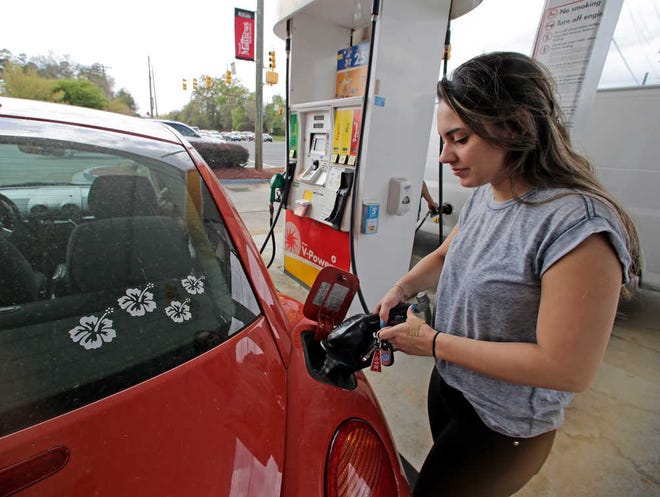 In this Monday, April 6, 2015 photo, Lucy Perez, of Charlotte, N.C., pumps gas at a station in Matthews, N.C. Drivers will see the lowest summer gasoline prices in about 6 years, according to an Energy Department report released Tuesday. (AP Photo/Chuck Burton)