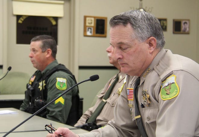 Sheriff Jon Lopey listens as Sergeant Bear Tharsing describes the investigation of a recent string of burglaries.