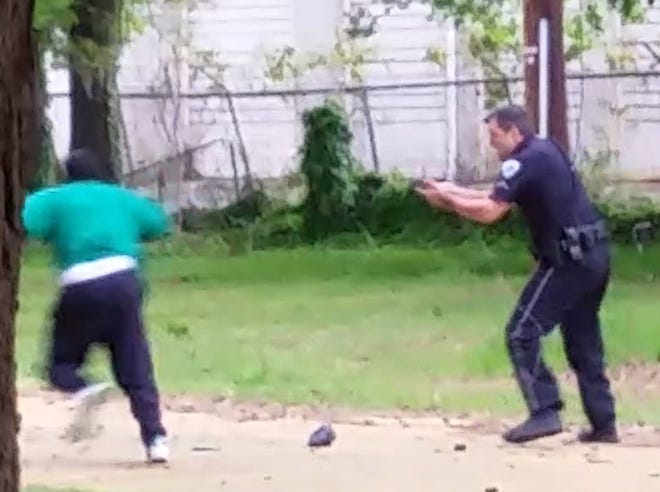 In this April 4 frame from video provided by Attorney L. Chris Stewart representing the family of Walter Lamer Scott, Scott appears to be running away from City Patrolman Michael Thomas Slager, right, in North Charleston, S.C. Slager was charged with murder on Tuesday hours after law enforcement officials viewed the dramatic video that appears to show him shooting a fleeing Scott several times in the back.