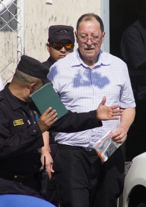 Police escort former General Eugenio Vides Casanova to a car outside the airport in San Salvador, El Salvador, Wednesday, April 8, 2015. The ex-general linked to human rights abuses during El Salvador’s civil war in the 1980’s was deported by the U.S. on Wednesday. He had been living in Florida since he retired in 1989, but was taken into custody by U.S. immigration authorities in late March after the United States’ top immigration court ruled that he should be deported.