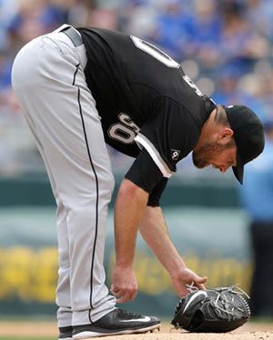 Chicago White Sox starting pitcher John Danks (50) makes adjustments while waiting for a play review during the first inning of a baseball game against the Kansas City Royals at Kauffman Stadium in Kansas City, Mo., Thursday, April 9, 2015. (AP Photo/Orlin Wagner)