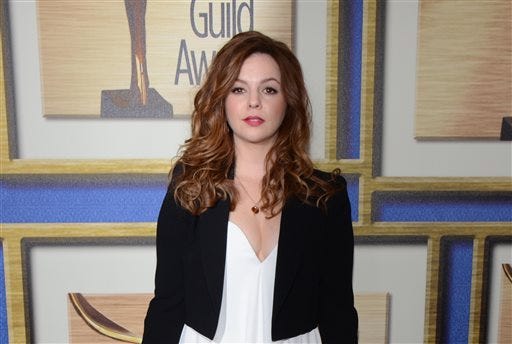 In this Feb. 1, 2014 file photo, Amber Tamblyn arrives at the Writers Guild Awards, in Los Angeles. Tamblyn's new book of poetry called "Dark Sparkler" (Harper Perennial) is a downer, a magnifying glass about the way we immortalize particularly young women in Hollywood and a catalyst for web browsing all rolled into one. "The book is about the lives and deaths of celebrity women in a certain way but it's also about voyeurism, it's also about projection, it's also ... what it's like to be an object for a living," said Tamblyn in a recent interview with Associated Press. (Photo by Tonya Wise/Invision/AP, File)