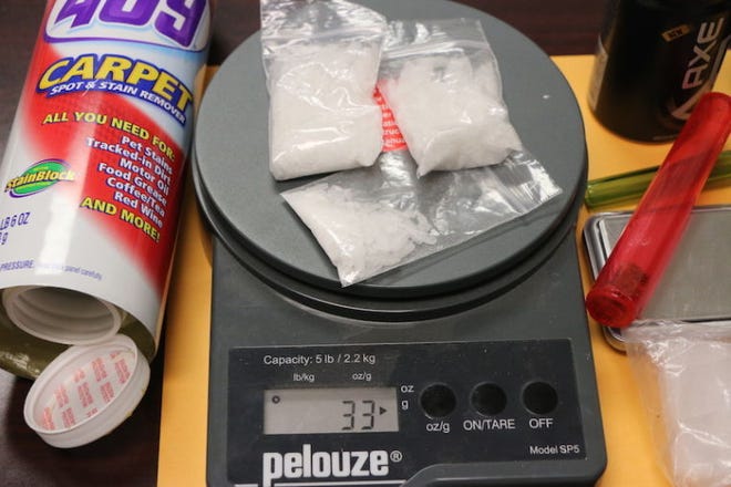 Sheriff's narcotics detective Robert Ramirez weighs methamphetamine that was seized in a traffic stop Thursday afternoon. Other seized items include a smoking pipe, small digital scales and what Ramirez described as "hide-a-cans" where narcotics are sometimes hidden.