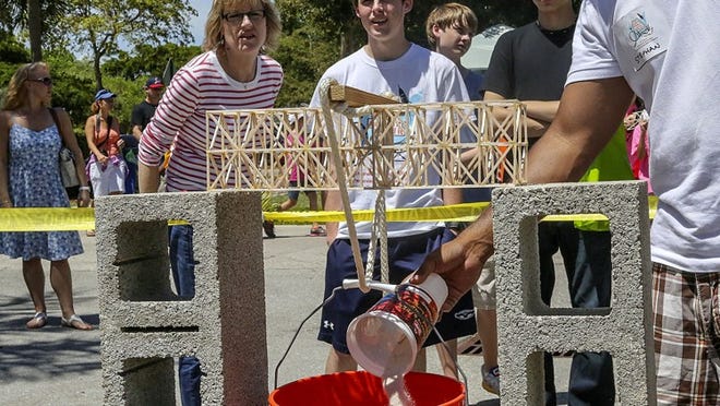 Griffin Beesley, 17, of FAU high school, watches to see how much weight his bridge can hold during the 29th annual Drop it, Build it, Float it, Launch it, Thrill it engineering competition at the South Florida Science Center on Saturday. (Damon Higgins / The Palm Beach Post)