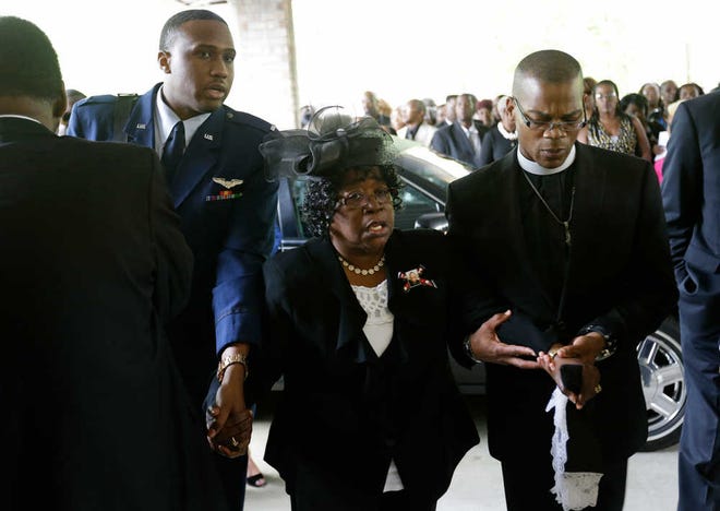 David Goldman/The Associated PressJudy Scott, center, is escorted in for the funeral of her son, Walter Scott, at W.O.R.D. Ministries Christian Center on Saturday in Summerville, S.C.