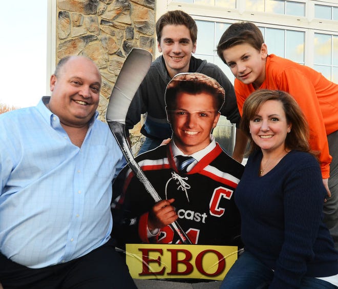 Posing with a cutout of their late son Eric, known as  "Ebo," in his team Comcast hockey jersey are parents Steve and Gini Eberling and their sons, Bill, 17, (second from left) and Andrew, 13.