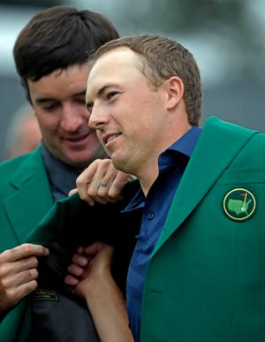 Bubba Watson helps Jordan Spieth put on his green jacket after winning the Masters on Sunday in Augusta, Ga. (AP Photo/Charlie Riedel)
