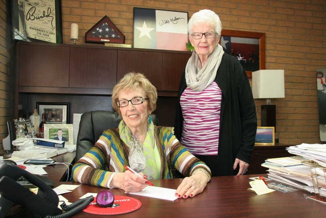 Geneva Boren, seated at desk, and Genet Cooper, standing, still are actively working in a multifaceted business that Geneva started in 1960.