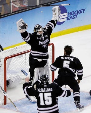 Providence goalie Jon Gillies (32) raises his arms as he celebrates with teammates Kyle McKenzie (5) and Steven McParland (15) after they beat Boston University 4-3 in the NCAA men's Frozen Four hockey championship game in Boston, Saturday, April 11, 2015. (AP Photo/Elise Amendola)