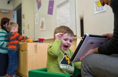 Calvin Gowdy, 2, shows his excitement as he works on a iPad with therapy assistant Sarah Fitch, right, at The Autism Program of Illinois Clinic at the Noll Medical Pavilion on March 11, 2015, in Springfield, Ill. Gov. Bruce Rauner has proposed a total elimination of the $4.3 million in state funding that the program receives. Justin L. Fowler/The State Journal-Register