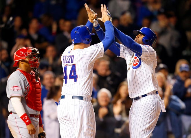 Chicago Cubs first baseman Anthony Rizzo (44) greets right fielder Jorge Soler, right, after his eighth inning homerun as Cincinnati Reds catcher Brayan Pena, left, watches during the eighth inning of a baseball game in Chicago, on Monday, April 13, 2015. (AP Photo/Jeff Haynes)