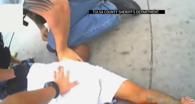 In this screen shot from April 2, 2015 video provided by the Tulsa County Sheriff's Office, police restrain 44-year-old Eric Harris after he was chased down and tackled by a Tulsa County Deputy, and then shot by a reserve sheriff's deputy while in custody, in Tulsa, Okla.