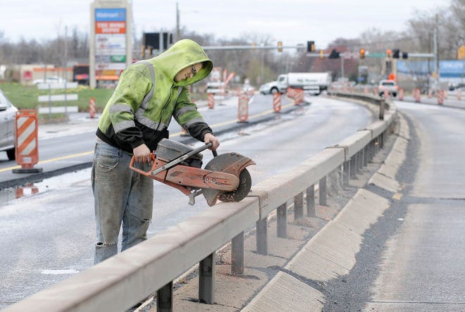 A worker cuts through a guard rail along Route 13 in Tullytown, Pennsylvania, on Tuesday.