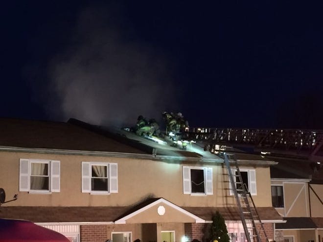 Firefighters attempt to vent smoke coming from a second-floor apartment fire in Warrington Tuesday night.