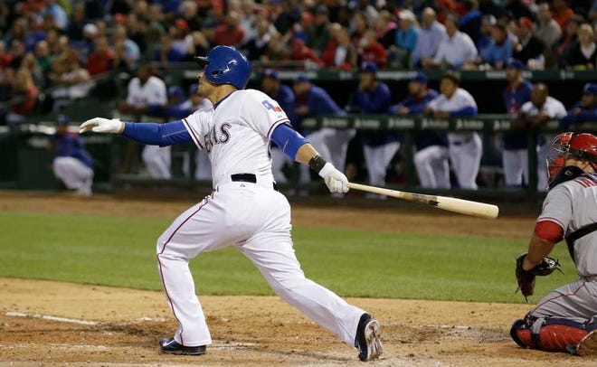 Texas Rangers' Robinson Chirinos watches his RBI double, in front of Los Angeles Angels catcher Chris Iannetta during the second inning of a baseball game in Arlington, Texas, Tuesday, April 14, 2015. The Rangers won 8-2. (AP Photo/LM Otero)