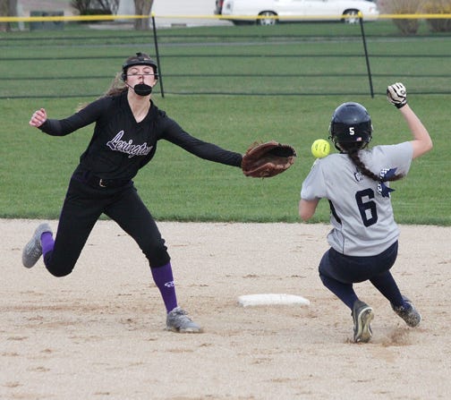 Fieldcrest baserunner Hannah Peterson takes the ball off her shoulder as she steals second base. Trying to catch the ball is Lexington shortstop Carlee Lype.