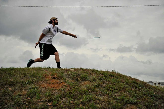 Georgia Regents' Dakota Bailey drives on the 11th hole in the first round of the National Collegiate Disc Golf Championships. The defending champion Jaguars are in 24th place.