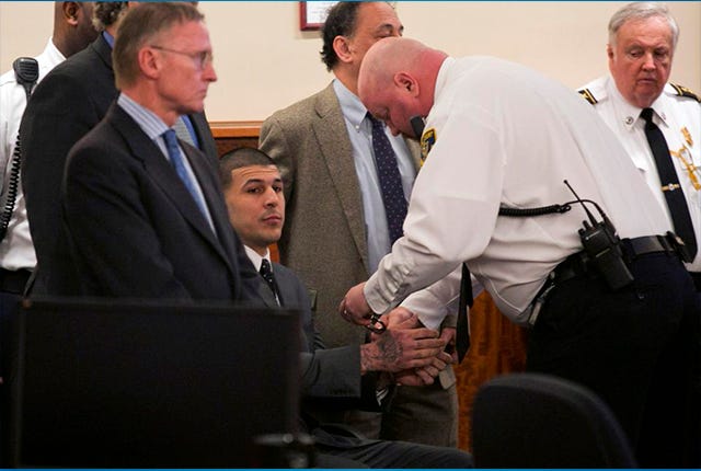 A court officer places handcuffs on the wrists of former New England Patriots football player Aaron Hernandez after the guilty verdict was read during his murder trial at the Bristol County Superior Court in Fall River, Mass., Wednesday, April 15, 2015. Hernandez was found guilty of first-degree murder in the shooting death of Odin Lloyd in June 2013. He faces a mandatory sentence of life in prison without parole. (Dominick Reuter/Pool Photo via AP)