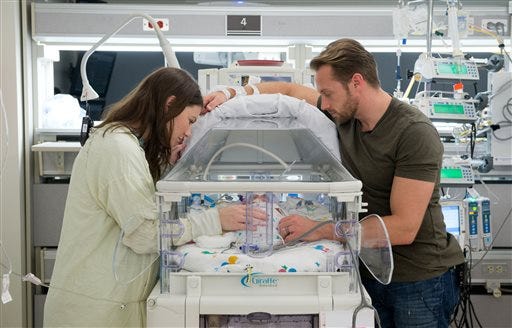 In this undated photo provided by The Woman's Hospital of Texas, parents Danielle, left, and Adam Busby spend time with Parker Kate, one of their quintuplets born on April 8, 2015, at The Woman's Hospital of Texas in Houston, Texas. The Woman's Hospital of Texas says it took four minutes for mother Danielle to deliver the babies by C-section last week. Busby, her husband Adam and her eldest daughter, Blayke, welcomed Olivia Marie, Ava Lane, Hazel Grace, Parker Kate and Riley Paige. (Charles Falk/The Woman's Hospital of Texas via AP)