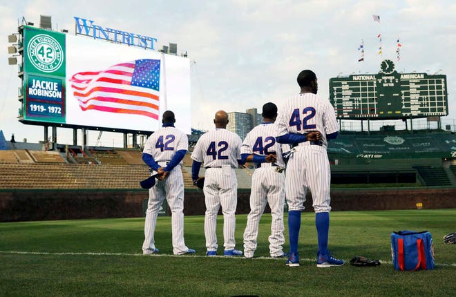 Chicago Cubs players wear No. 42 in recognition of Jackie Robinson Day before a baseball game against the Cincinnati in Chicago, Wednesday, April 15, 2015. (AP Photo/Nam Y. Huh)