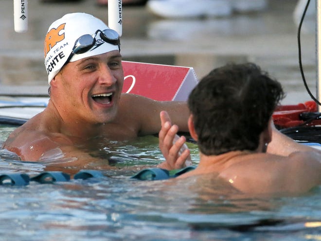 Ryan Lochte, left, congratulates Michael Phelps after Phelps won the men's 100 meter butterfly final Thursday at the Arena Pro Swim Series in Mesa, Arizona.