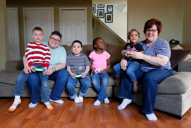 Jayne Rowse, left, and April DeBoer, right, pose with their adopted children Jacob, 5, from left, Nolan, 6, Ryanne, 6, and Rylee, 2, at their home in Hazel Park, Mich., Sunday, April 12, 2015. DeBoer and Rowse initially went to court to win the right to jointly adopt each otherís children, not to confront Michiganís ban on gay marriage. But three years later, the Detroit-area nurses sometimes canít buy groceries without supporters recognizing them and giving a hug. Each woman has adopted two kids, but they canít jointly adopt them because joint adoption in Michigan is tied to marriage. (AP Photo/Paul Sancya)