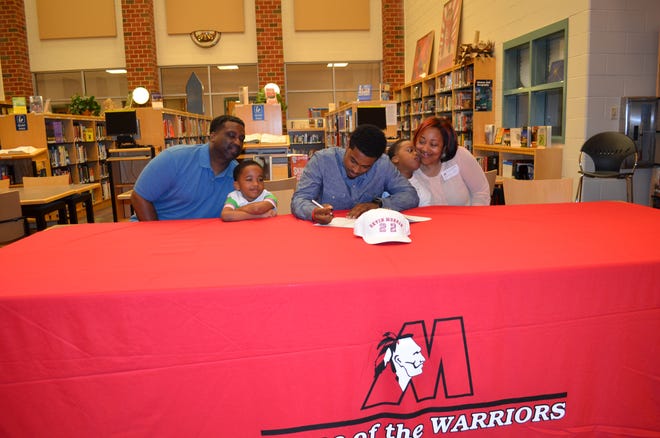 Matoaca senior guard Devin Morgan signs his official letter of intent to play Division I college basketball at Delaware State University next season in front of his family on Wednesday morning in Chesterfield. CONTRIBUTED PHOTO by Matoaca High School.