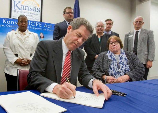 Gov. Sam Brownback signed into law Thursday legislation limiting Kansas welfare recipients to no more than $25 daily from an ATM and prohibiting expenditure of that cash on visits to swimming pools and movie theaters as well as casinos and liquor stores.