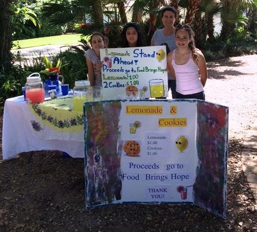 Connie Kent (center), mother of Cami Kent (not pictured), stands with Evelyn Kent, Kathryn Dana and Adrianna Mortola, all of Ormond Beach, at their lemonade stand benefitting Food Brings Hope. The girls decided to spend their Spring Break giving back to the community.