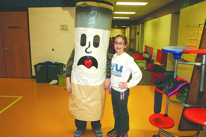 Sixth-graders Ryder Hawbecker, dressed as Ciggy, and Taylor Appenzellar mingled with third-, fourth- and fifth-graders at lunch during Kick Butts Day. They urged students not to smoke, that ‘Hugs Before Drugs’ was better.