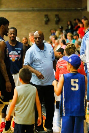 Former North Carolina basketball great Phil Ford, interacts with children during an ACC Barnstorming Tour game at East Duplin High School on Wednesday night. Ford played under the late Dean Smith from 1974 to 1978.