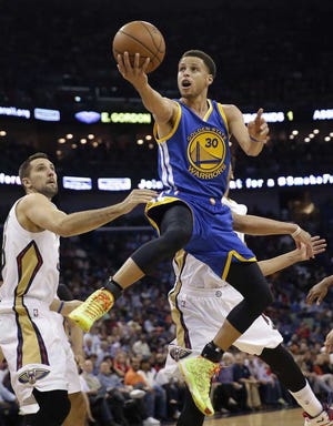 Golden State Warriors guard Stephen Curry (30) drives to the basket in front of New Orleans Pelicans forward Ryan Anderson in the first half of an NBA basketball game in New Orleans, Tuesday, April 7, 2015. (AP Photo/Gerald Herbert)