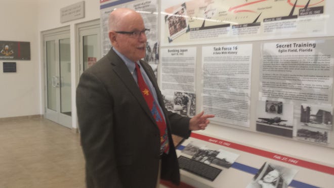 Dr. Frank Goldstein points out aspects of the Doolittle Raiders exhibit at Northwest Florida State College.