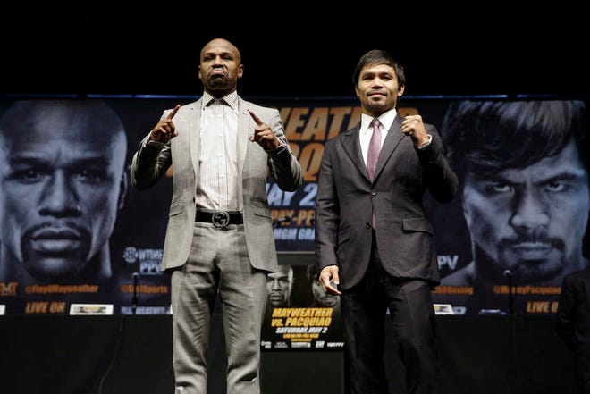 FILE - In this March 11, 2015, file photo, boxers Floyd Mayweather Jr., left, and Manny Pacquiao, of the Philippines, pose for photos after a news conference in Los Angeles. The two are scheduled to fight in Las Vegas on May 2. (AP Photo/Jae C. Hong, File)