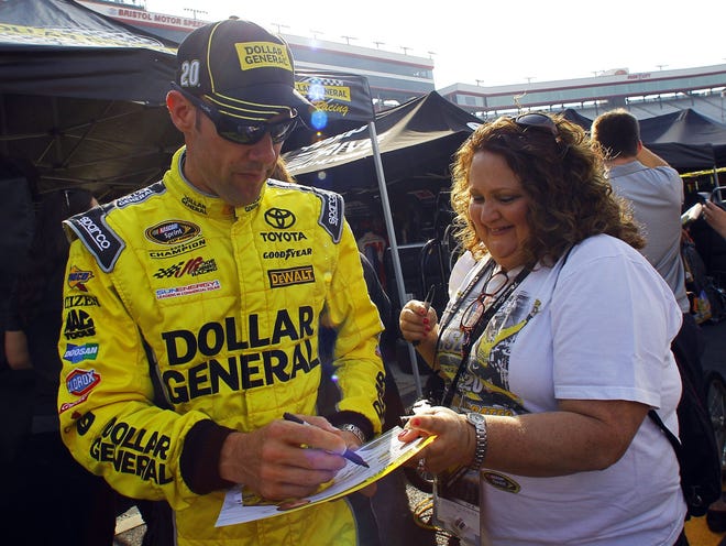 Driver Matt Kenseth signs an autograph for a fan during practice for a NASCAR Sprint Cup Series auto race at Bristol Motor Speedway on Saturday in Bristol, Tennessee.