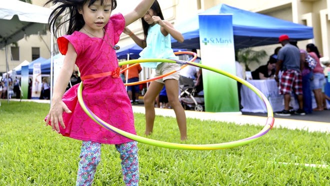 Khampeera Nong, 4, (L), of West Palm Beach, playing with a hoola hoop, along with her cousin, Kaitlin Nguyen, 11, during the first annual neonatal reunion at Children’s Hospital at St. Mary’s Medical center Apr 18, 2015, in West Palm Beach. Close to 450 families and children signed up for the event. (Bill Ingram / Palm Beach Post)