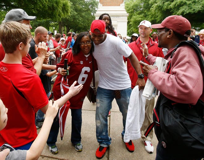 Marilyn Granville Davis, a 1998 graduate of the University of Alabama from Muscle Shoals, gets a hug from former Alabama team captain Blake Sims after the Walk of Fame ceremony at Denny Chimes on Saturday.