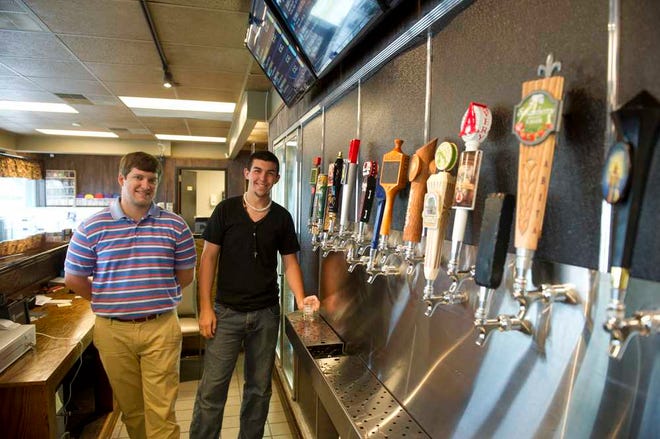 Connor Meeks (left) and Julian Cox work behind the counter at Tip Top Taps, a new growler store. The store was built on an old gas station and convenience store store site.